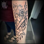 Black and grey scizzors over flower tattoo