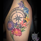 Compass with flowers around it tattoo