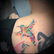 colorful bird on shoulder tattoo