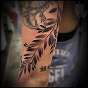 Fern leaves on wrist in black and grey tattoo